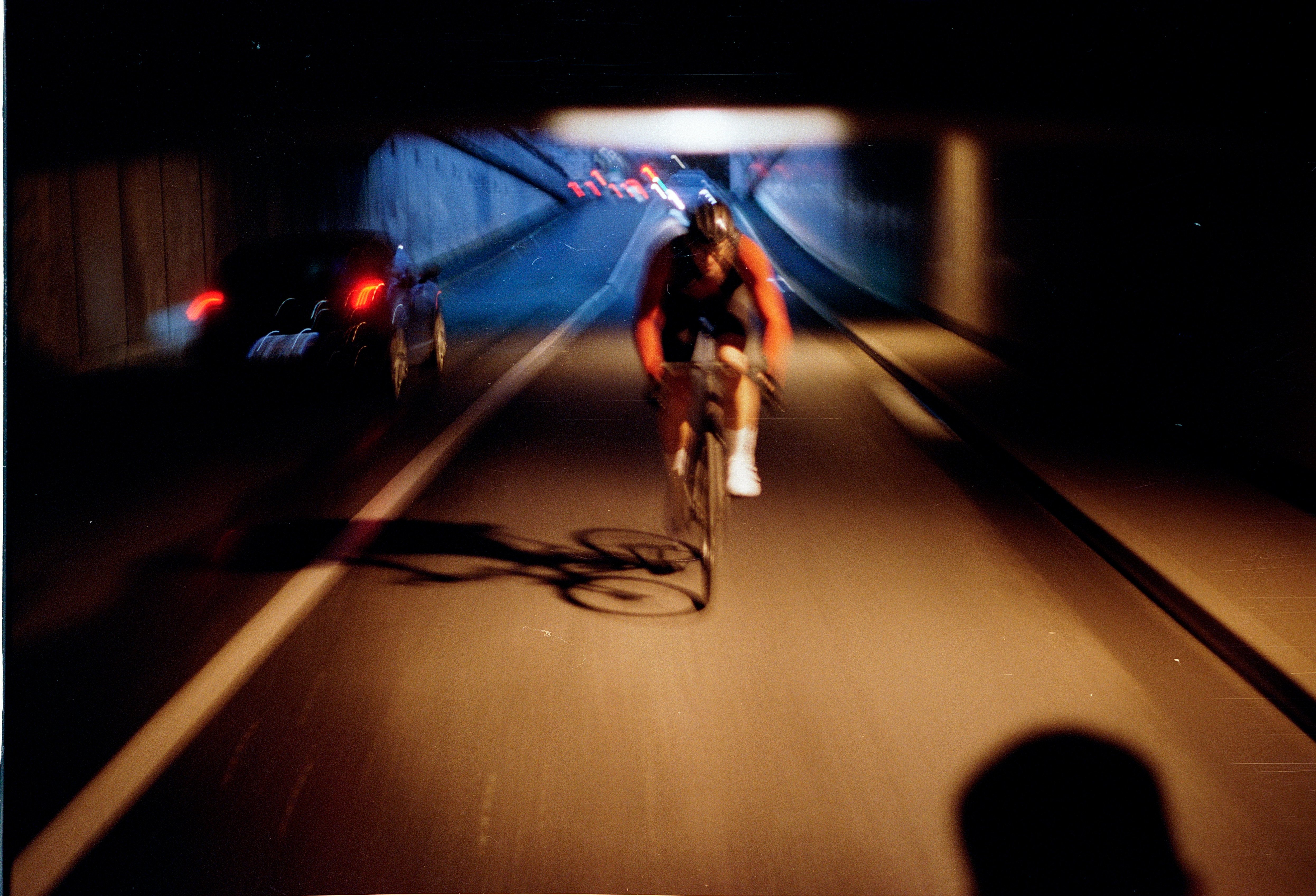 Fotografía con fuerte barrido de movimiento de cámara siguiendo al ciclista de la campaña Etxeondo por un túnel nocturno.